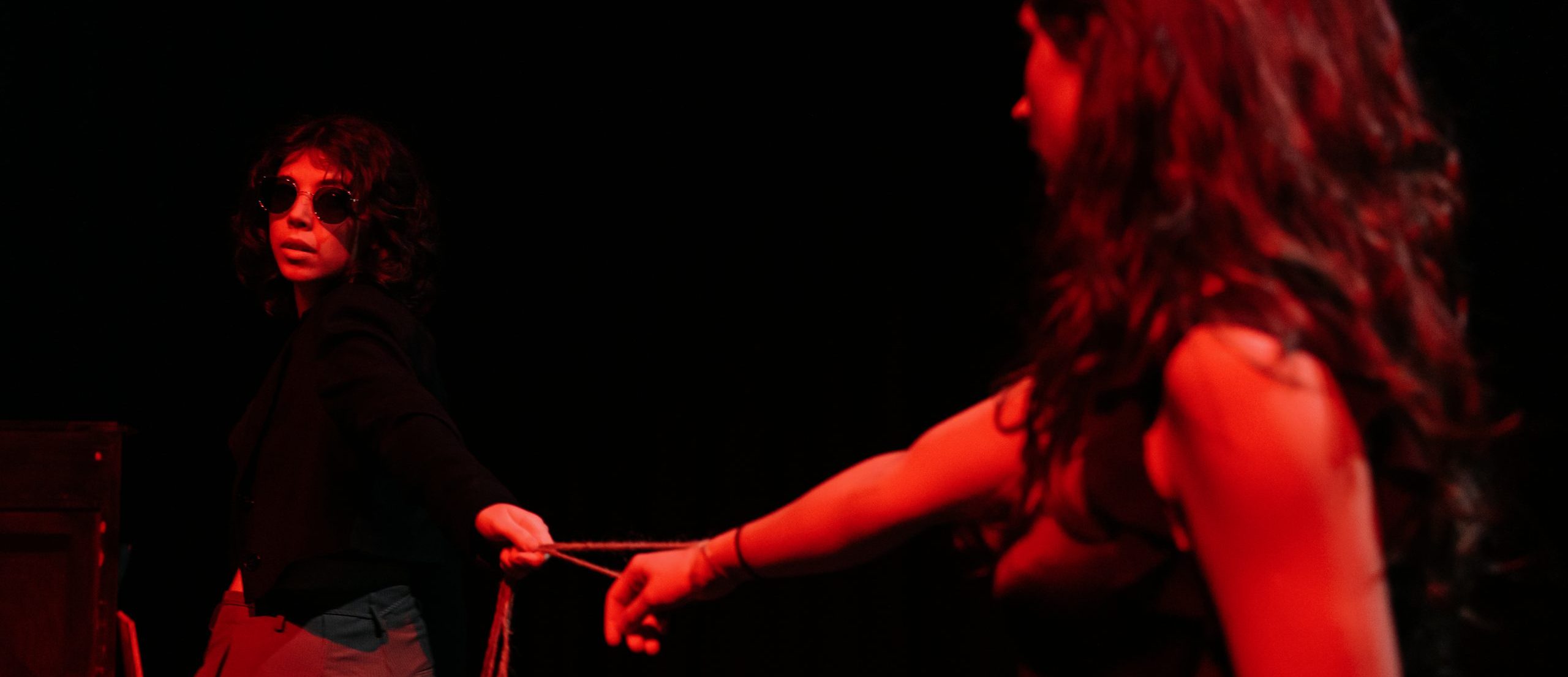 Two people standing with arms out stretched in dark room