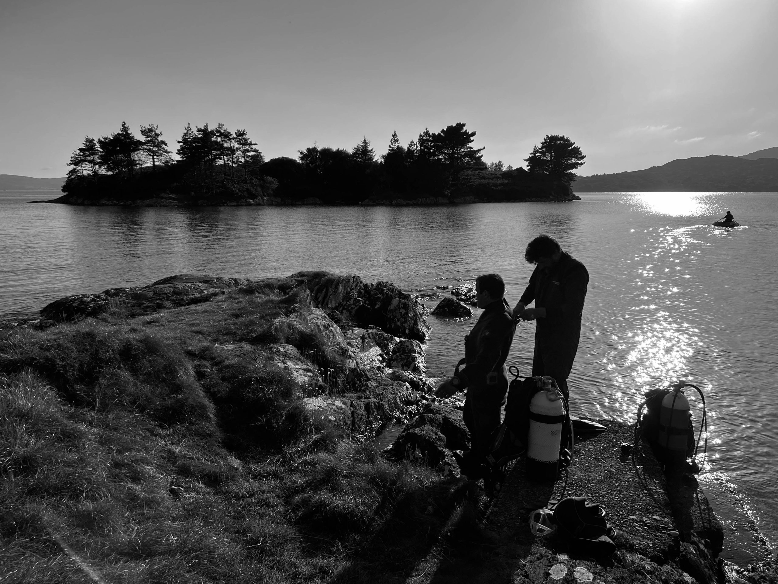 Divers suiting up beside water