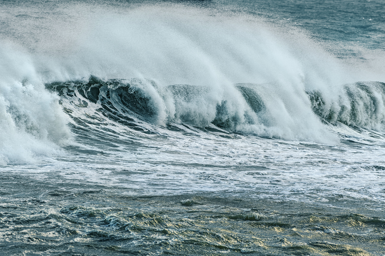 Powerful ocean wave breaking in stormy Irish Sea, showing raw sea energy and dramatic sea spray.